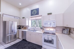 Enjoy cooking in this well-equipped kitchen with a refrigerator, oven, and ample cabinetry.