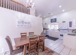 A modern kitchen with white cabinets, a microwave, an oven, and a sink. - The Hen House Monthly Rental (Payson)