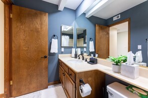 Tina con regadera, toallas, shampoo, papel de baño 