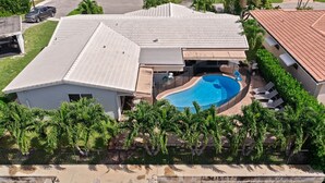 Ein Wohnhaus mit Swimmingpool, einer überdachten Terrasse und Blick auf das Wasser.