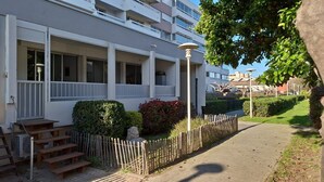 A modern apartment building with a covered outdoor area, steps leading to a door, and a wooden fence. - 2-bedroom apartment with terrace and parking, beach 70 metres away (Mauguio)