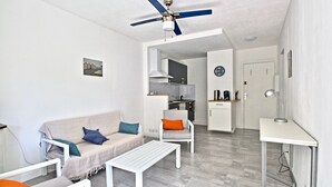 A modern living room with a sofa, coffee table, and a dining area with a table and chairs. - 2-bedroom apartment with terrace and parking, beach 70 metres away (Mauguio)