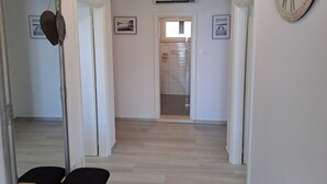 A hallway with a mirror, a clock, and framed pictures on the walls. - Korcula vacation home (Blato)
