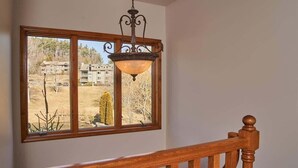 Eine Holztreppe mit Blick auf eine Wohngegend durch ein großes Fenster.