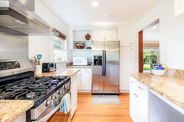 Enjoy cooking and dining in this well-equipped kitchen with a refrigerator, stove, microwave, and toaster.