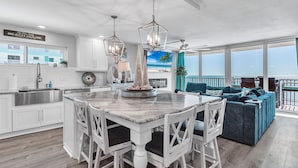 A modern kitchen with white cabinetry, a marble island, and pendant lighting. - ☀Beachfront Condo🌴Stunning Updates👙Heated Pool🐬Trillium 3A🏖️Beach Access (Madeira Beach)