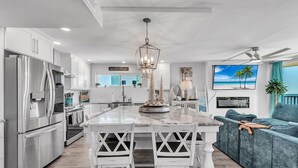 A modern kitchen with a central island, stainless steel appliances, and a view of the beach. - ☀Beachfront Condo🌴Stunning Updates👙Heated Pool🐬Trillium 3A🏖️Beach Access (Madeira Beach)