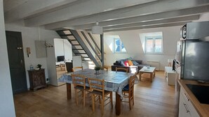 Une cuisine moderne équipée d’une cuisinière intégrée, d’un réfrigérateur et d’un coin repas avec une table et des chaises.