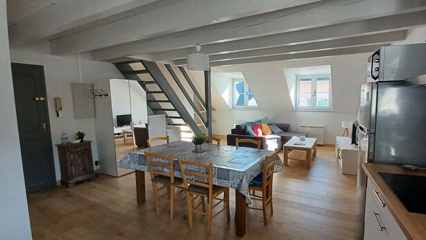 Une cuisine moderne équipée d’une cuisinière intégrée, d’un réfrigérateur et d’un coin repas avec une table et des chaises.