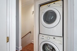 A laundry room with two stacked front-loading washing machines. - Sunnyside Up - Shared Pool (Key West)