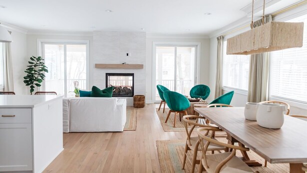 Une cuisine moderne avec un îlot central, une table à manger en bois et des chaises de couleur turquoise.
