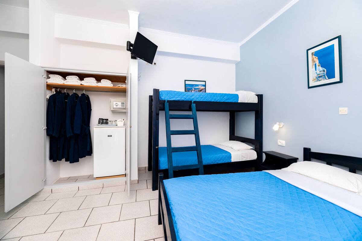 A bedroom with bunk beds, a desk, and a wardrobe.