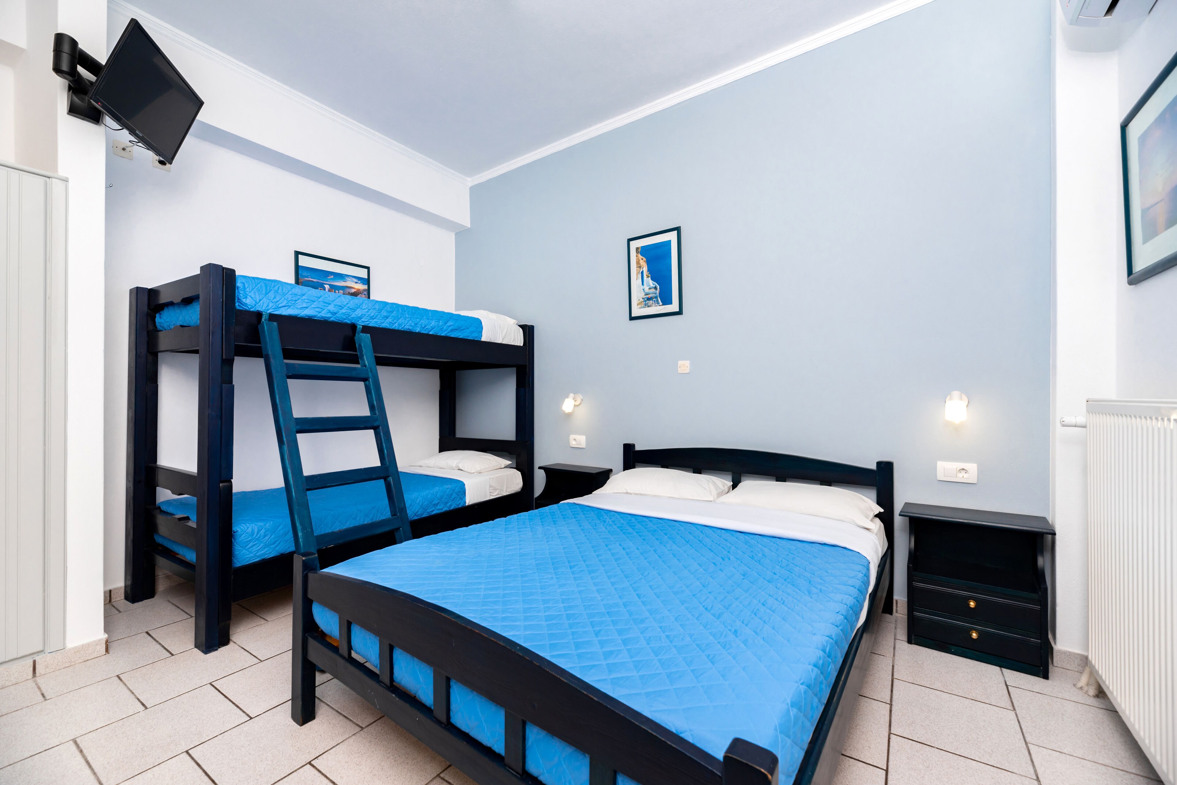 Une chambre avec deux lits superposés, un bureau avec un ordinateur et une petite table de chevet avec une lampe.