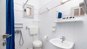 Ett modernt badrum med toalett, handfat och dusch.