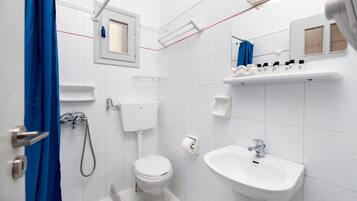 Vierpersoonskamer | Badkamer | Een douche, handdoeken