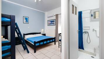 Un dormitorio con literas, una cama individual, una mesita de noche y una ventana con un cuadro.