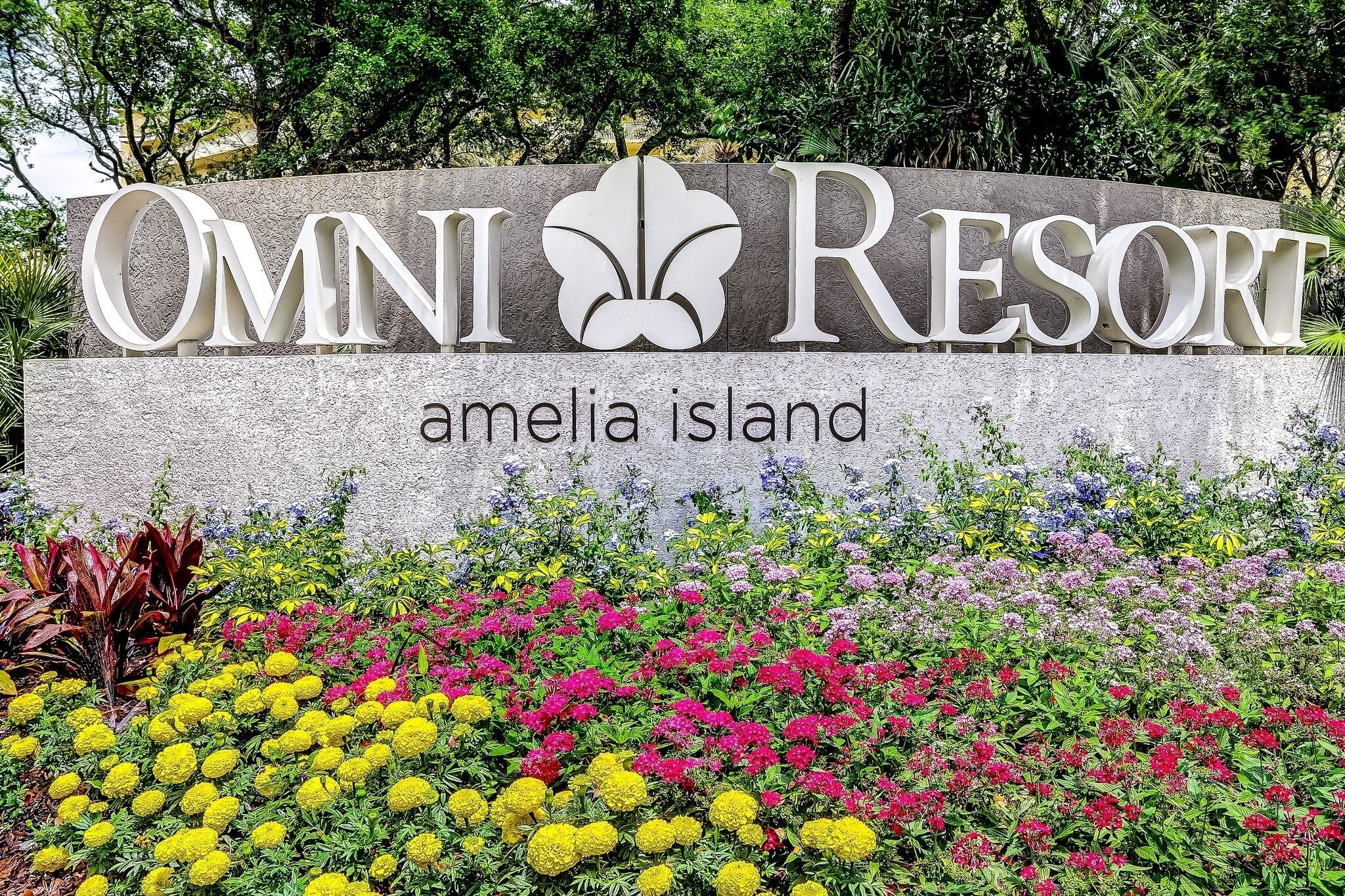Schild für Omni Resort Amelia Island mit einem Blumenbeet im Vordergrund.