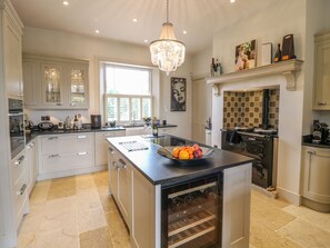 Una cocina moderna con una isla central, un enfriador de vinos y una chimenea.