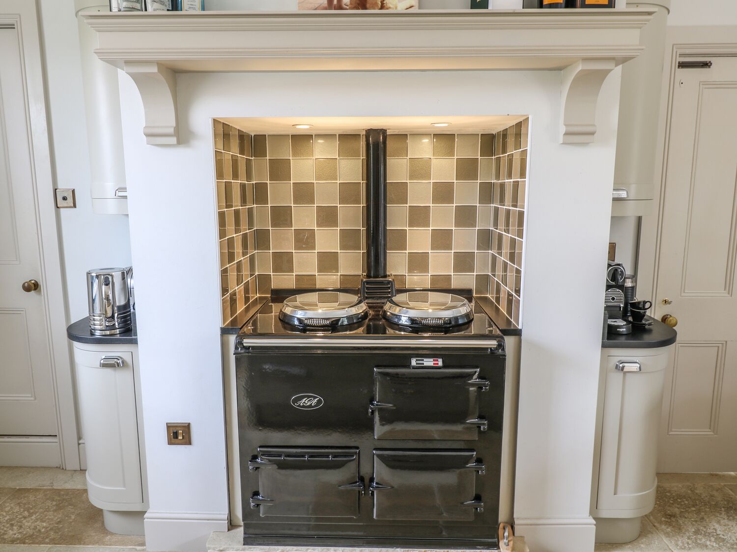 A kitchen with a built-in stove, a coffee maker, and a microwave on the countertop.