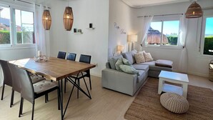 Un salon moderne comprenant un coin repas, un ensemble de canapés et une vue sur l’extérieur.