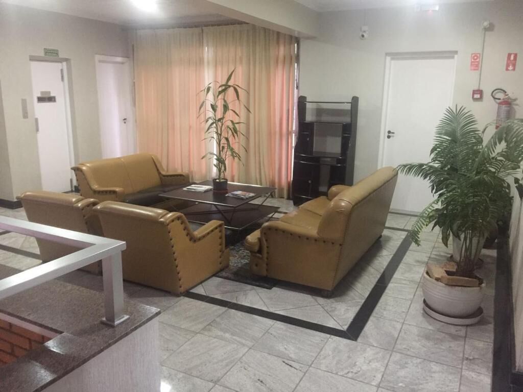 A living room with a sofa set, a coffee table, and a potted plant.