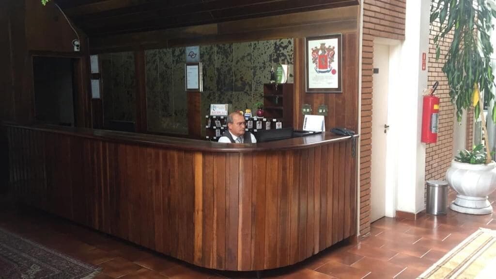 Una recepción con detalles de madera, un extintor en la pared y un escudo en cuadro.