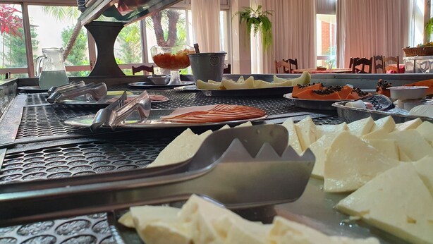 A buffet setup with various food items and utensils. - Ancona Center Hotel (Amparo)