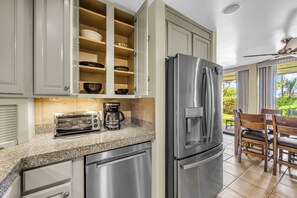 A kitchen with a stainless steel refrigerator, a toaster, and a coffee maker on the counter.