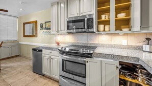 A modern kitchen with stainless steel appliances, a built-in oven, and a microwave.