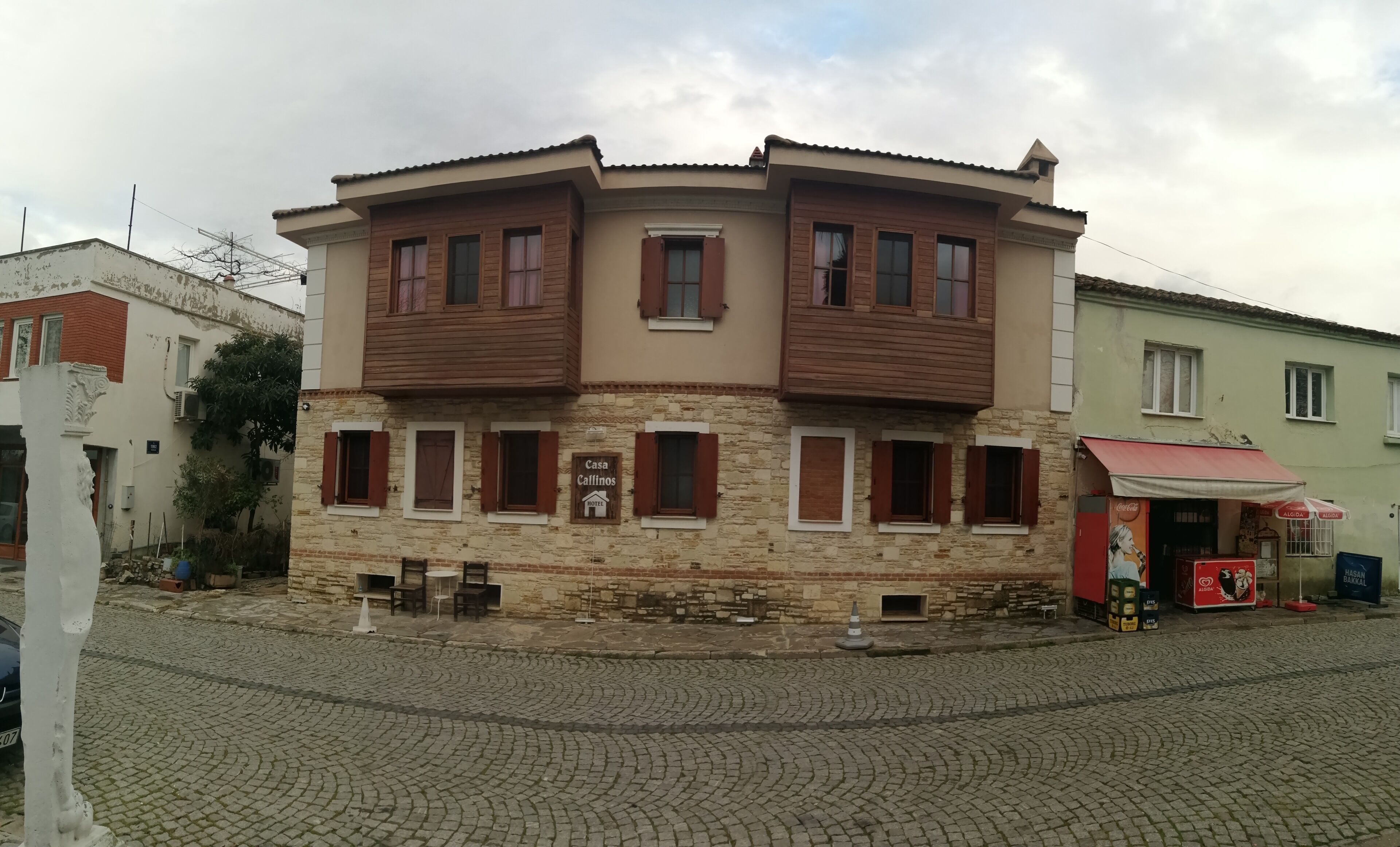 A two-story building with a stone facade and wooden shutters.