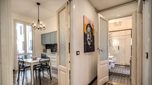 Un pasillo con comedor, cocina y baño.