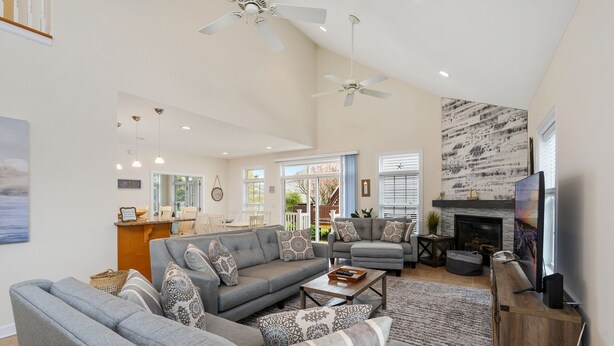 A spacious living room with a gray sectional sofa, a fireplace, and a television.