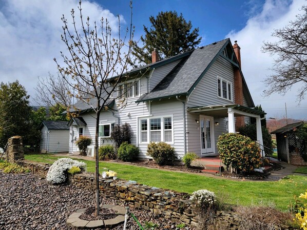 Ein zweistöckiges Haus mit Satteldach, einer Veranda und einem Steinfundament.