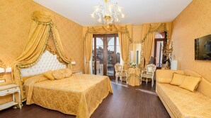 A luxurious bedroom with a large bed, a sofa, and a dining area.
