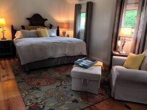 Cozy retreat with a large bed, nightstands, and a comfortable chair.