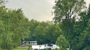 Eine Holzhütte am Seeufer mit Terrasse und Bootsanleger.