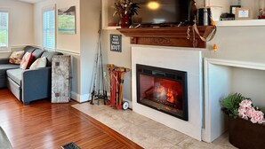 Ein Wohnzimmer mit Kamin, einer Couch und einem Fernseher.