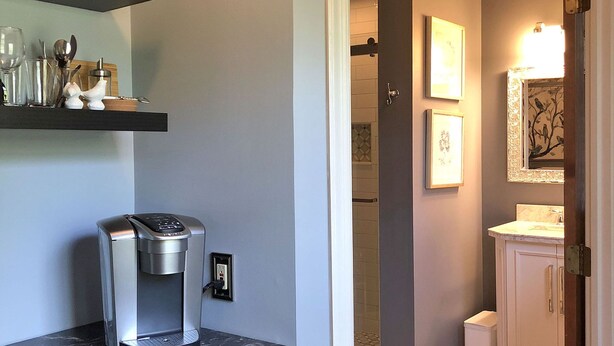 Una cocina con cafetera, refrigerador y mostrador.