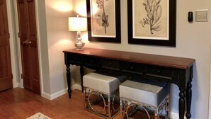 A hallway with a wooden bench, a table with a lamp, and two framed botanical prints on the wall. - The Cardinal Suite at Harpers Ferry Guest House (Harpers Ferry)