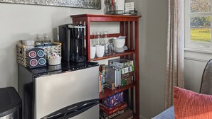 Une petite cuisine équipée d’un réfrigérateur, d’une machine à café et d’étagères de rangement.