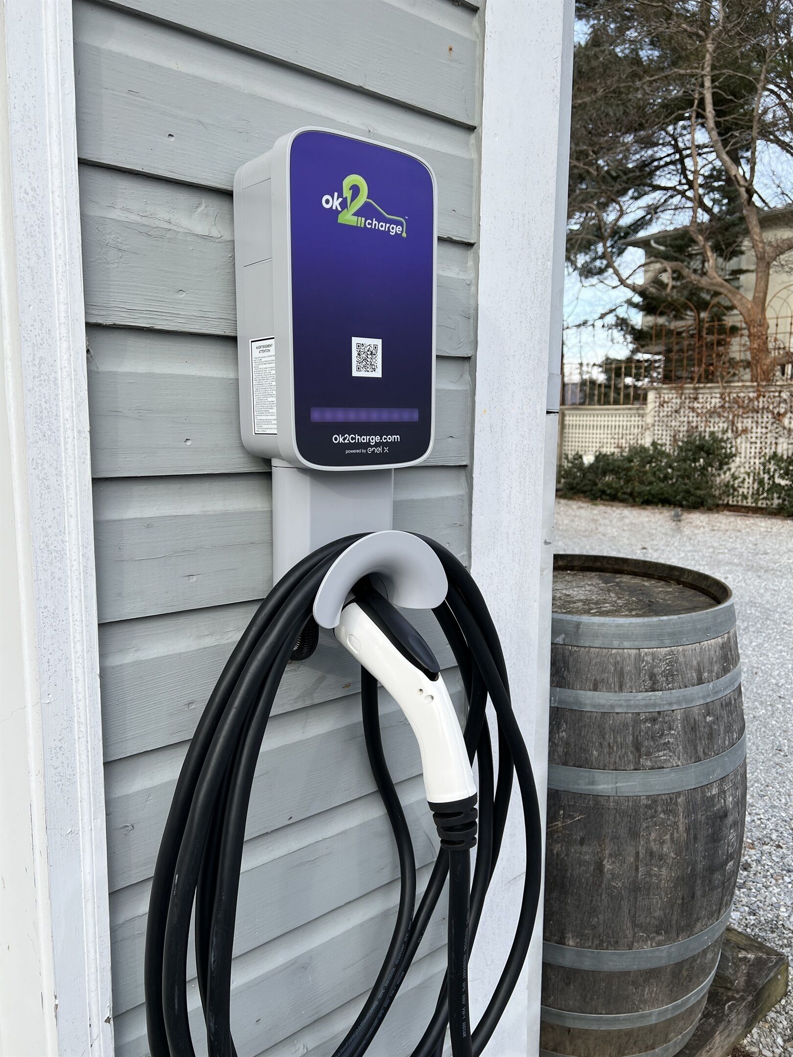 Une borne de recharge pour véhicules électriques fixée au mur d’une maison.