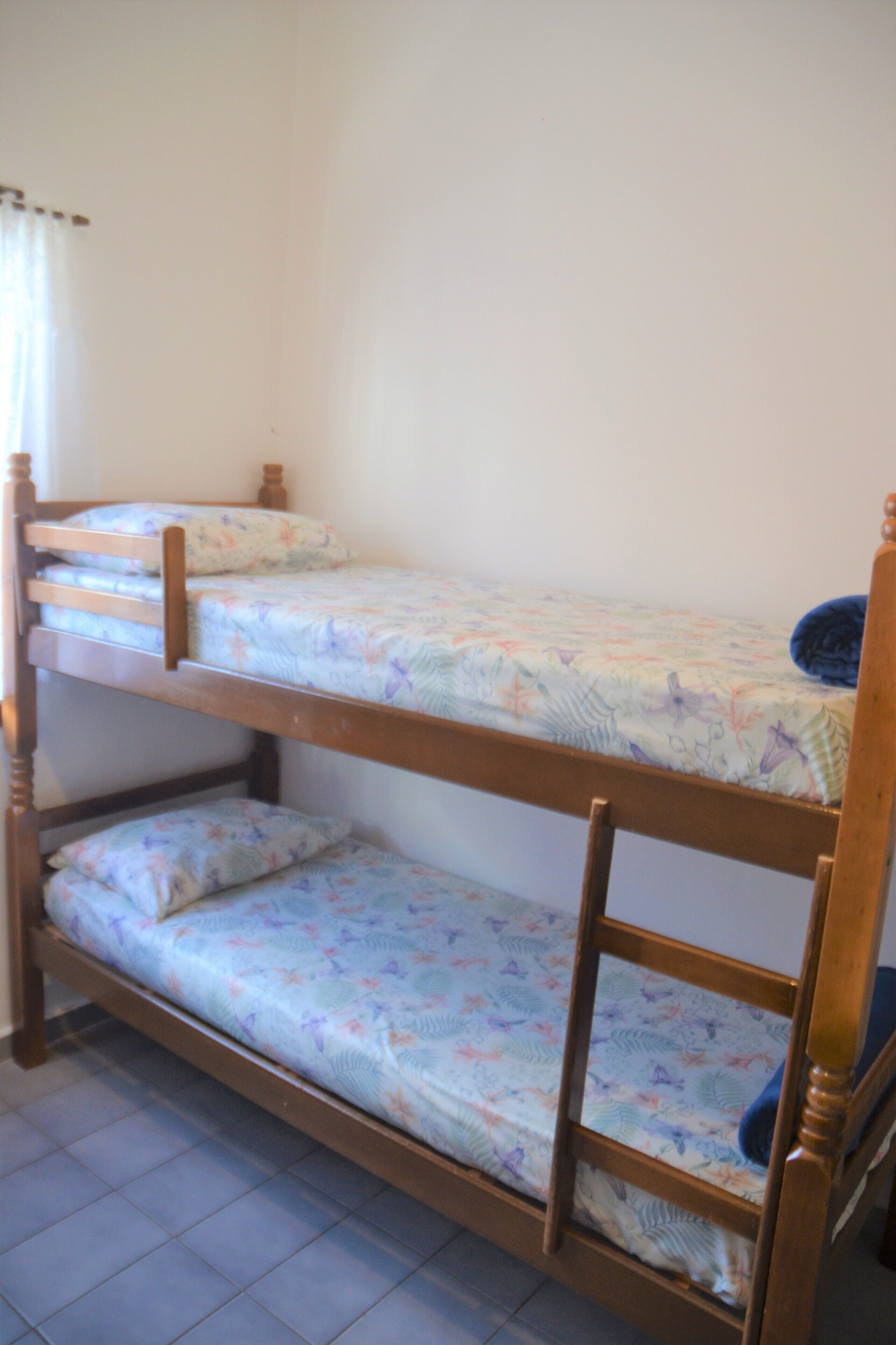 A bunk bed with floral bedding and wooden headboards.