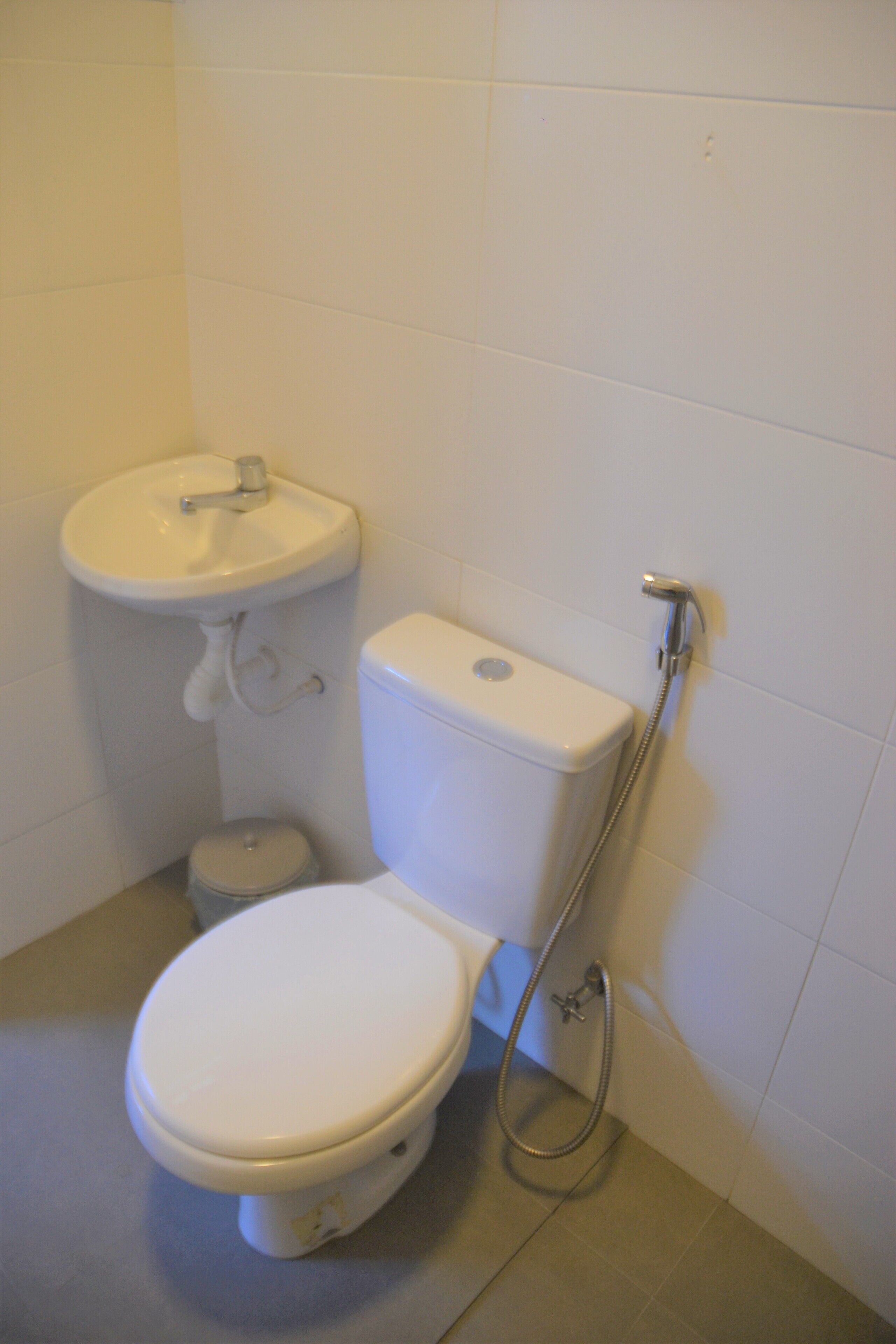 Une salle de bain avec des toilettes, un lavabo et une douche.