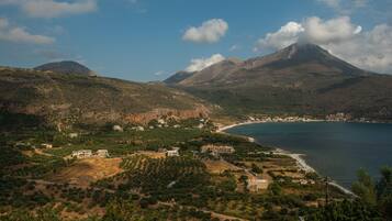 A coastal landscape with a mountain, a beach, and scattered buildings.
