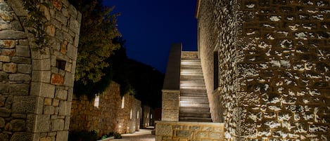 Un sendero de piedra que conduce a una escalera en un patio, de noche.