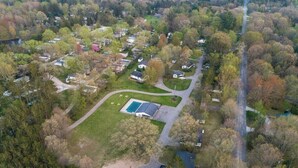Luchtbeeld van een woongebied met huizen, een zwembad en een weg.