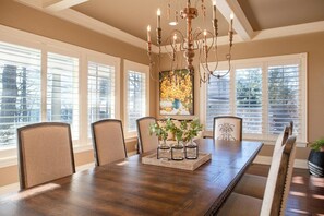 Enjoy meals in this elegant dining room with a large table, comfortable chairs, and a beautiful chandelier.