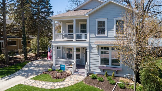 A two-story house with a front porch, a small garden, and an American flag. - Charming Home in Douglas - Sleeps 14 (Douglas)