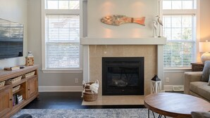 A living room with a fireplace, a television, and a sofa. - Charming Home in Douglas - Sleeps 14 (Douglas)