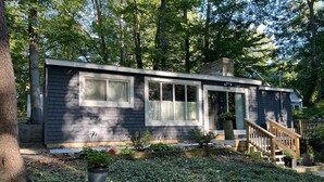 A small, single-story cabin with a front porch and a staircase leading to the entrance. - Updated Cozy Cabin near Lake Michigan (Holland)